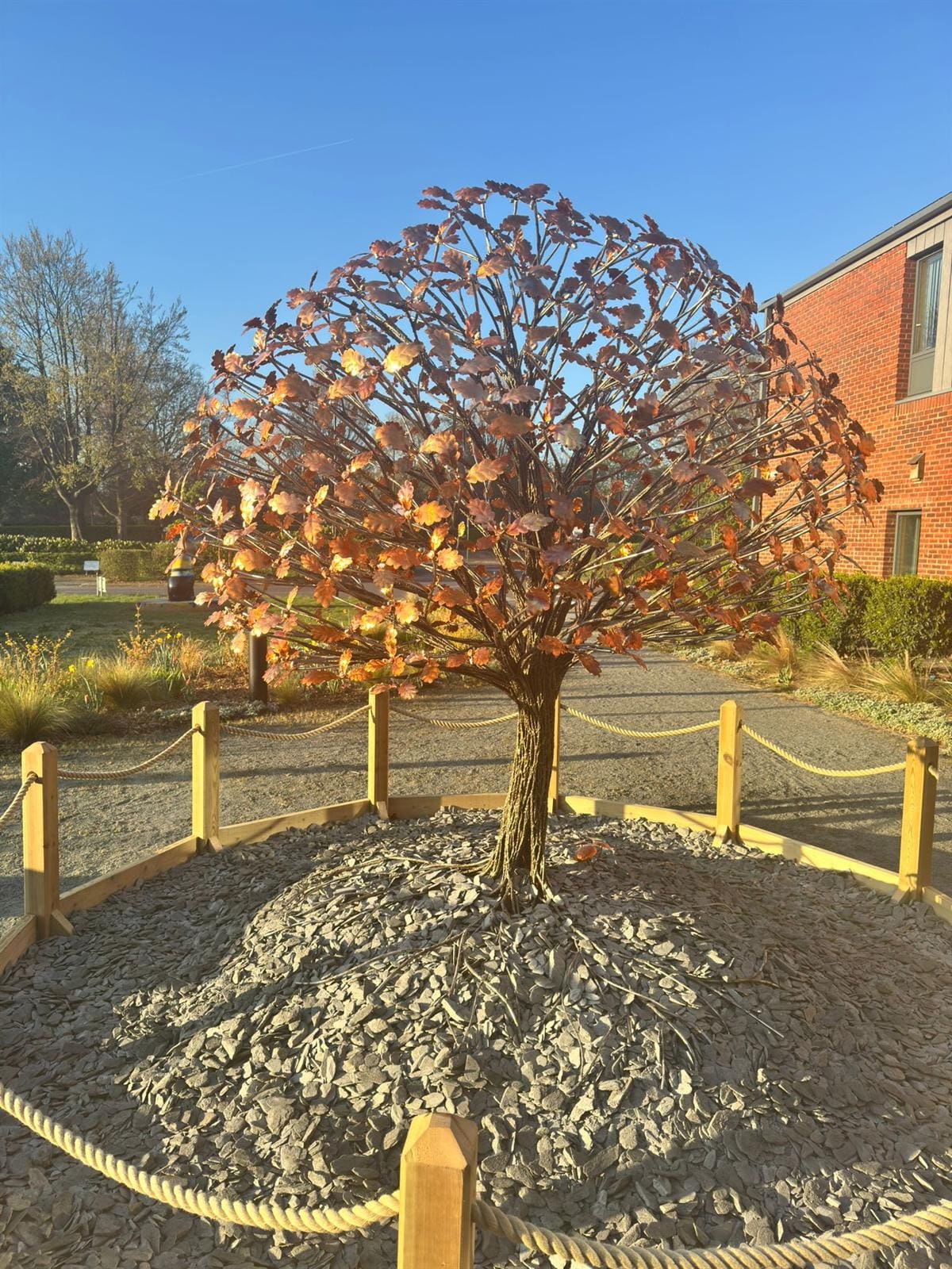 A tree in copper and steel standing in the grounds at Fairhavens Hospice on a clear morning